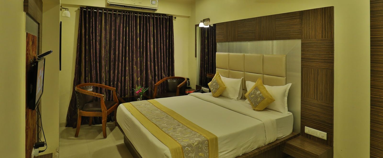 A bright hotel room with a neatly made bed, modern furniture, and warm ambient lighting - Retreat Heritage, Lonavala