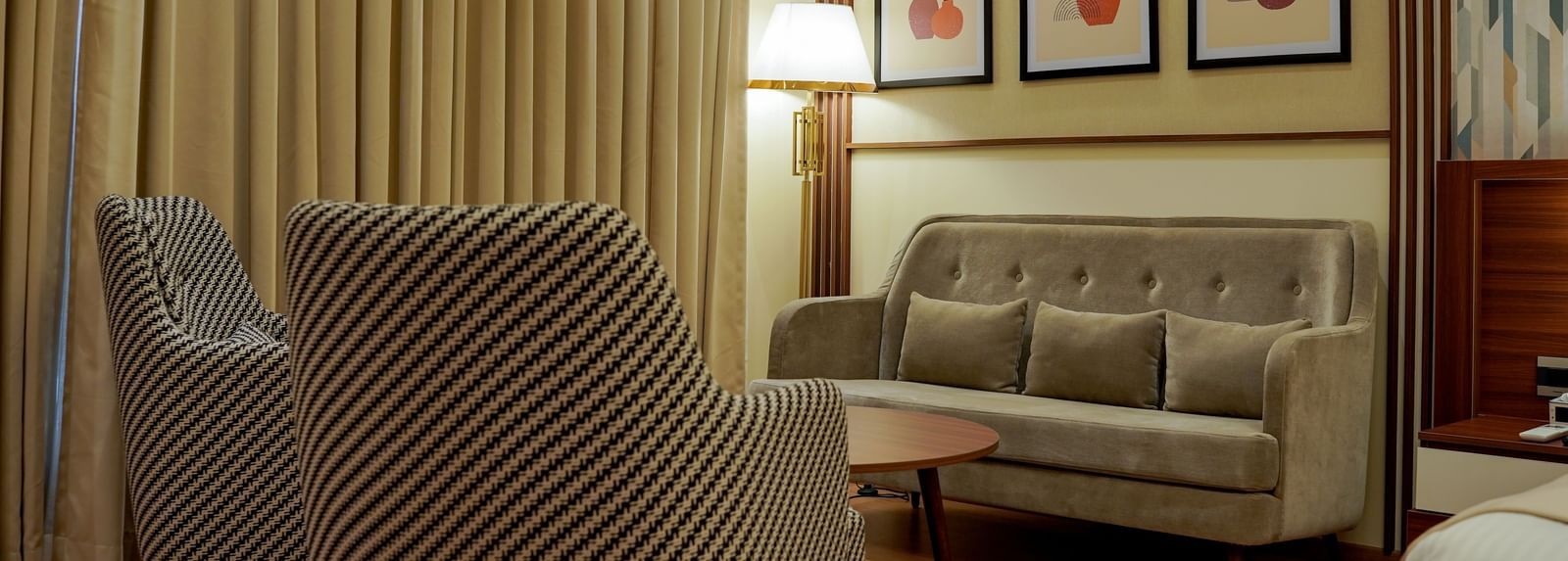 A close-up shot of the separate seating area with a tall lamp in the corner in the premium room at M2 Square by Monday Premium.