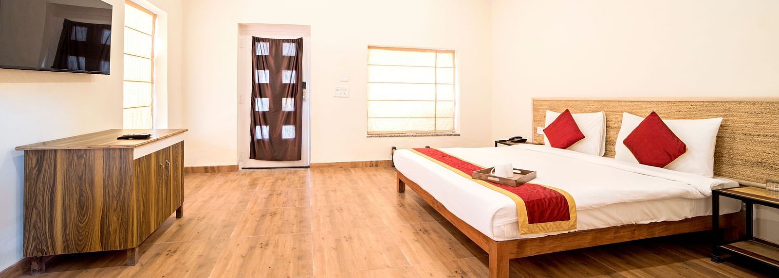 Side view of a room featuring a bed, a television, and a cupboard at Valley by Grassfield. 