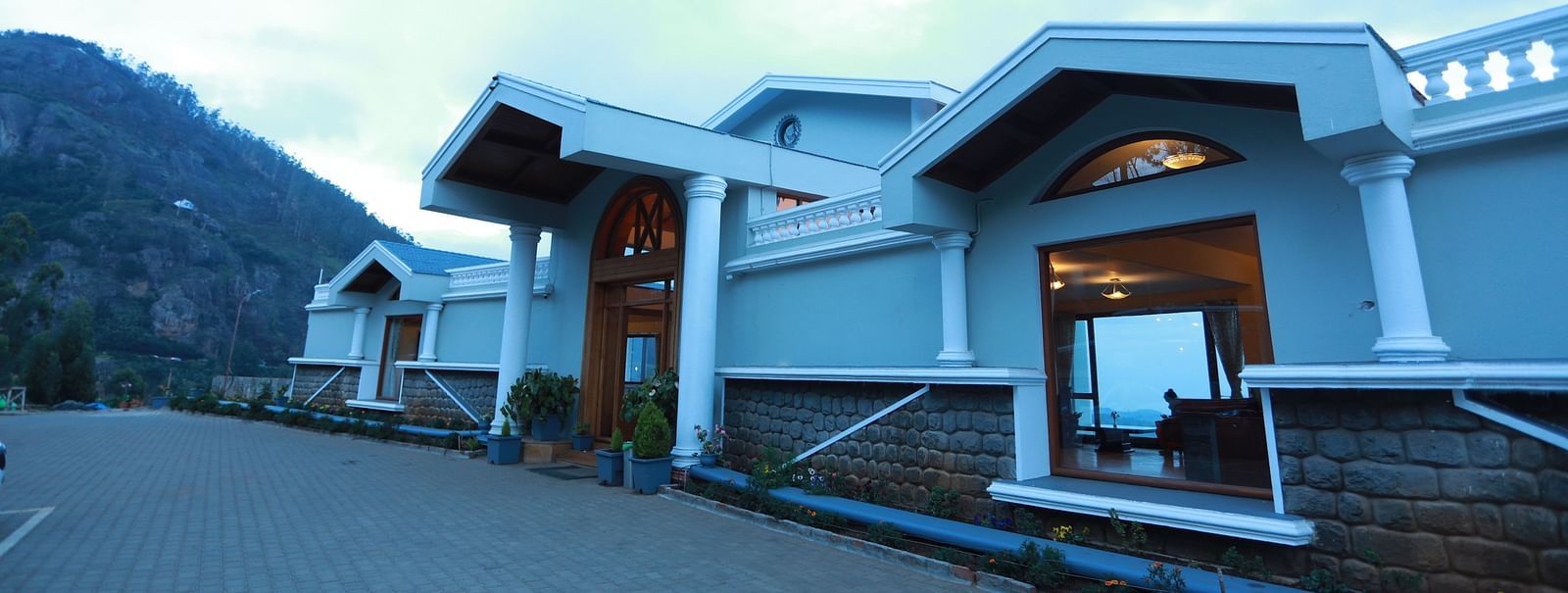 facade of La Montana By TGI, Ooty surrounded by mountains during daytime