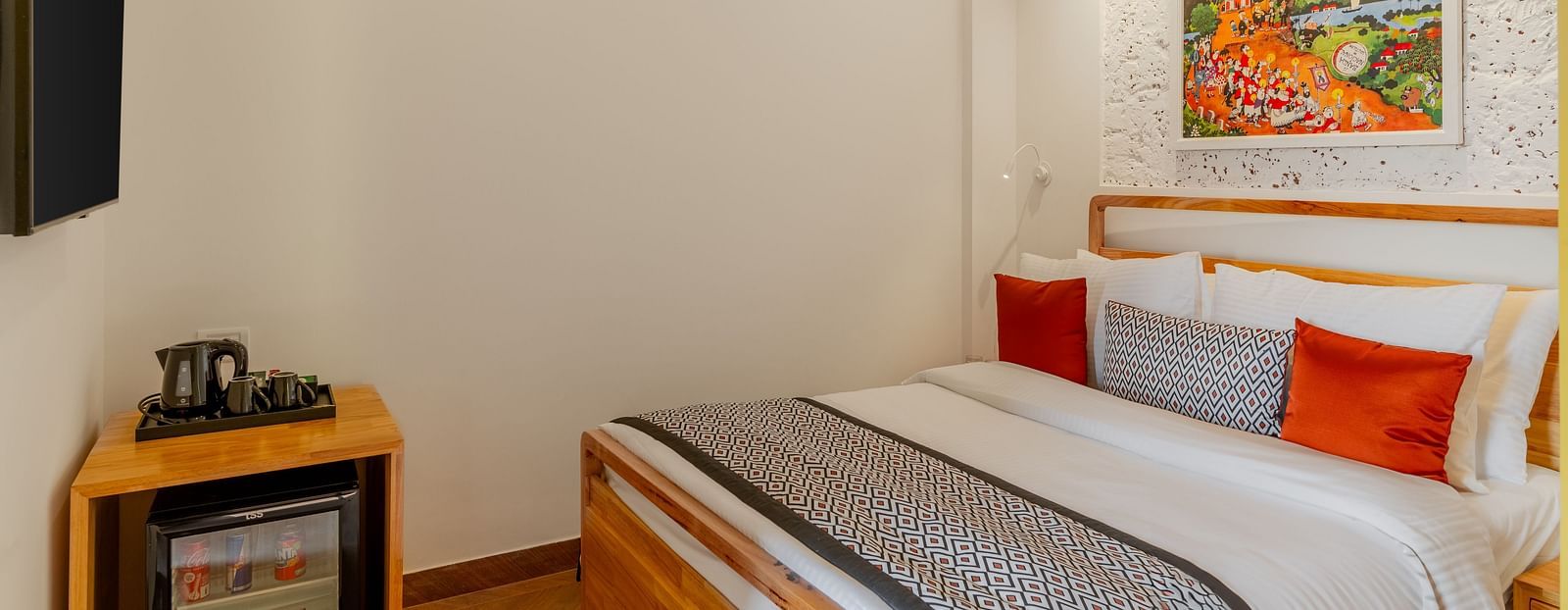 Cosy hotel room with a double bed and wall-mounted TV at Bedzzz Xclusiv Morjim, Goa