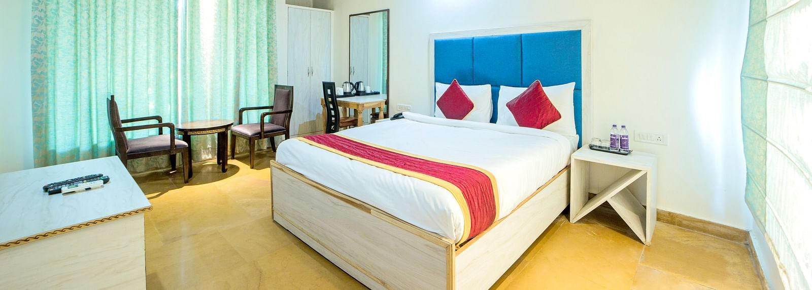 A room with a bed, a ceiling fan, and a seating area beside the window at Valley by Grassfield.