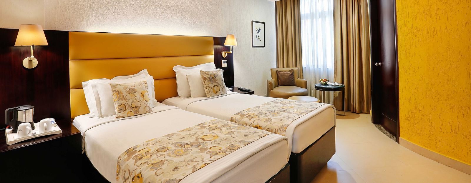 Hotel room featuring twin beds with bedside lights.