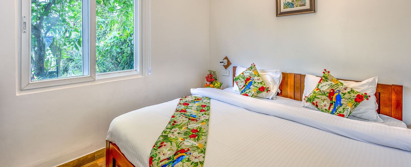 a double bed with many pillows and a table runner in one of the rooms - neer ganga resorts