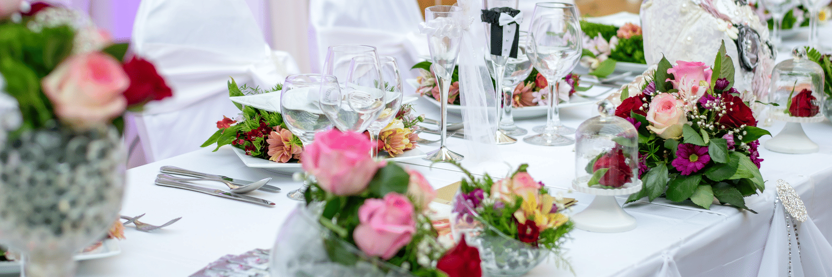 a table decorated with flowers at an event hall for a party