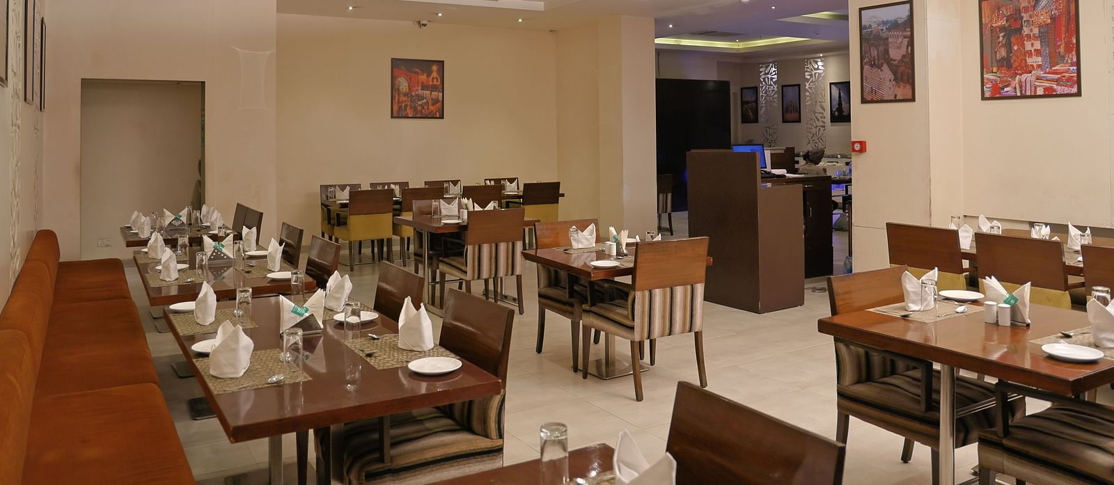 Wooden tables and chairs are grouped in fours, each table set with culinary dishes