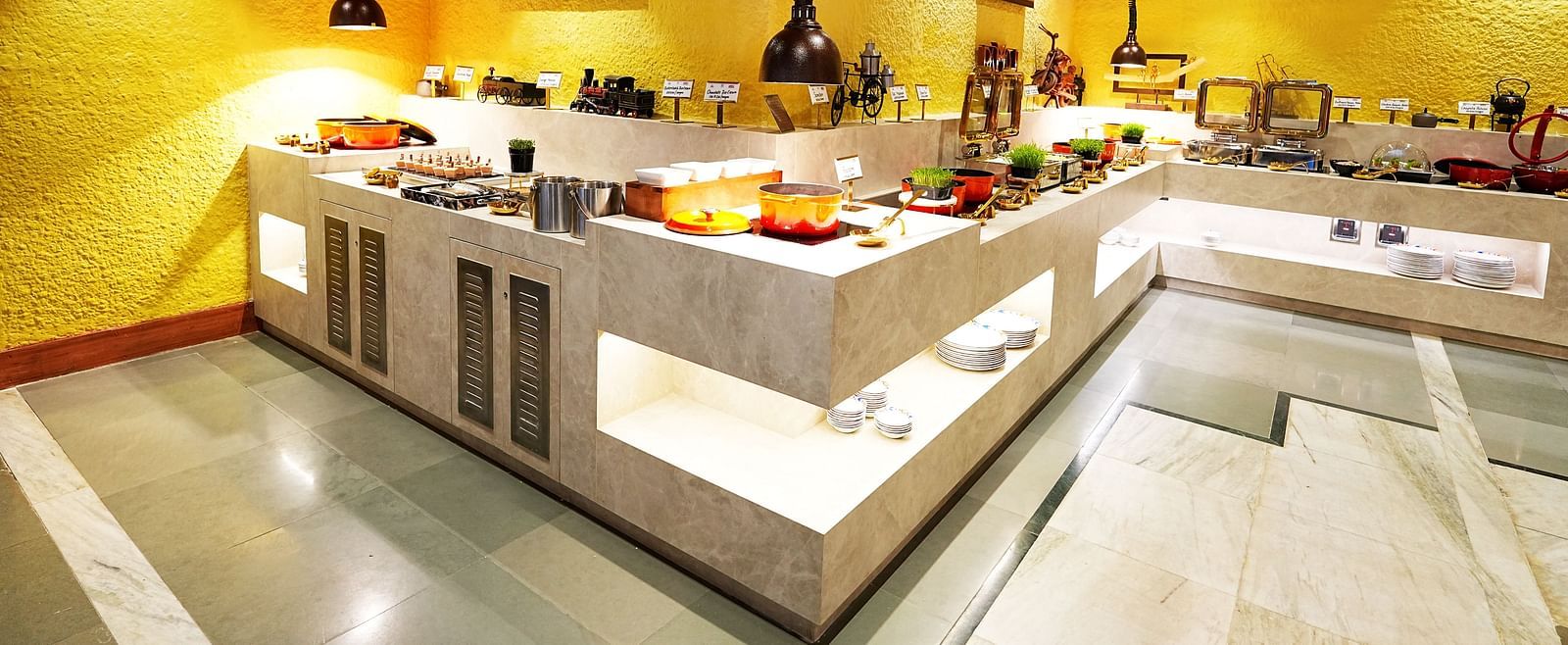 A well-arranged buffet line in a room with yellow walls and wooden ceiling at Tara, Comfort Hotel in Hyderabad - Ramoji Film City.