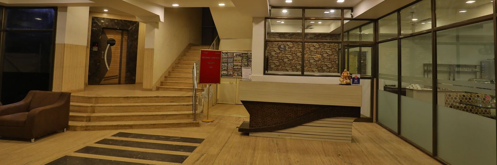 A hotel lobby area showcasing a reception desk, comfortable seating, and stairs leading upwards - Retreat Heritage, Lonavala