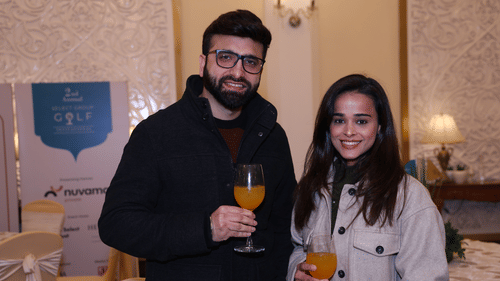 Two people stand close, each holding a glass with a drink. - Heritage Village Resorts & Spa