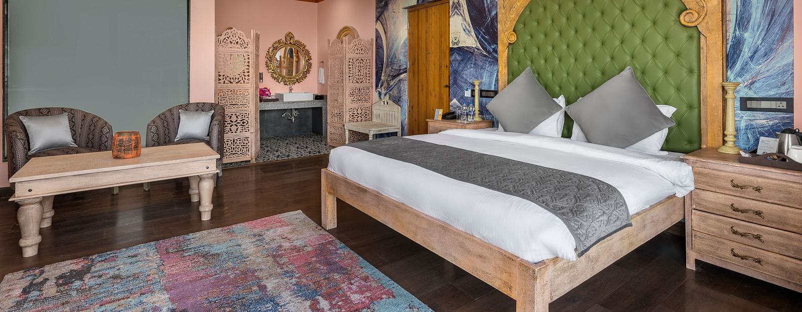 a bedroom with a large double bed and two sofas with a table - Atman, Dharamshala