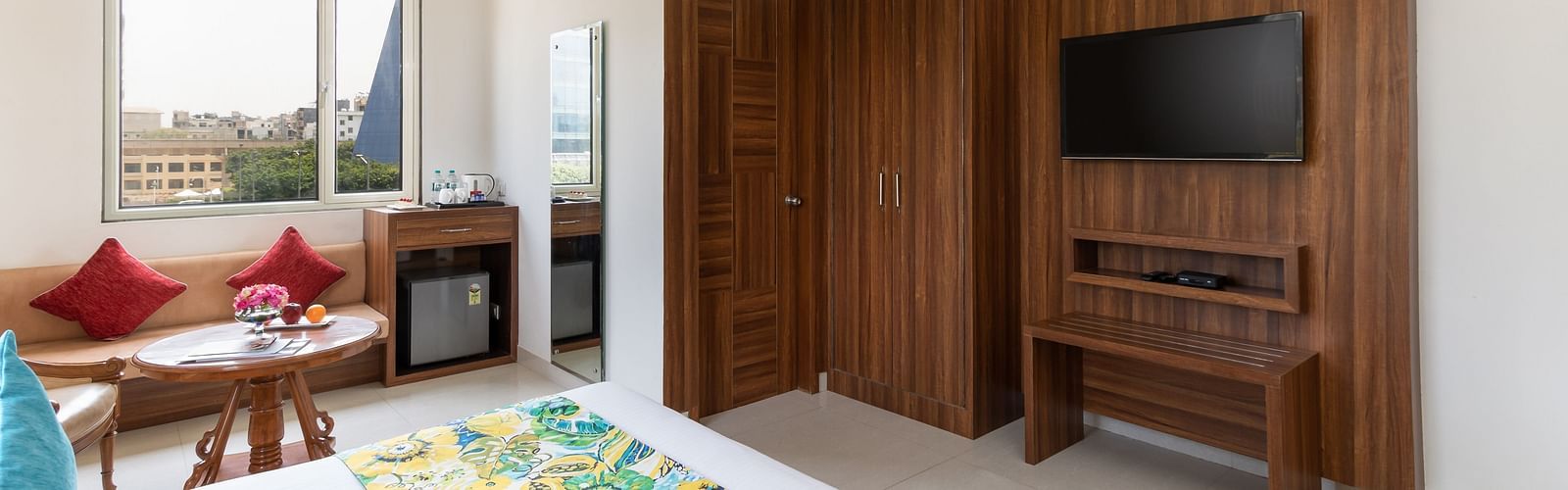 Side view of a spacious hotel room featuring a king size bed, comfortable seating, and modern amenities | Inde Hotel Cyber City 