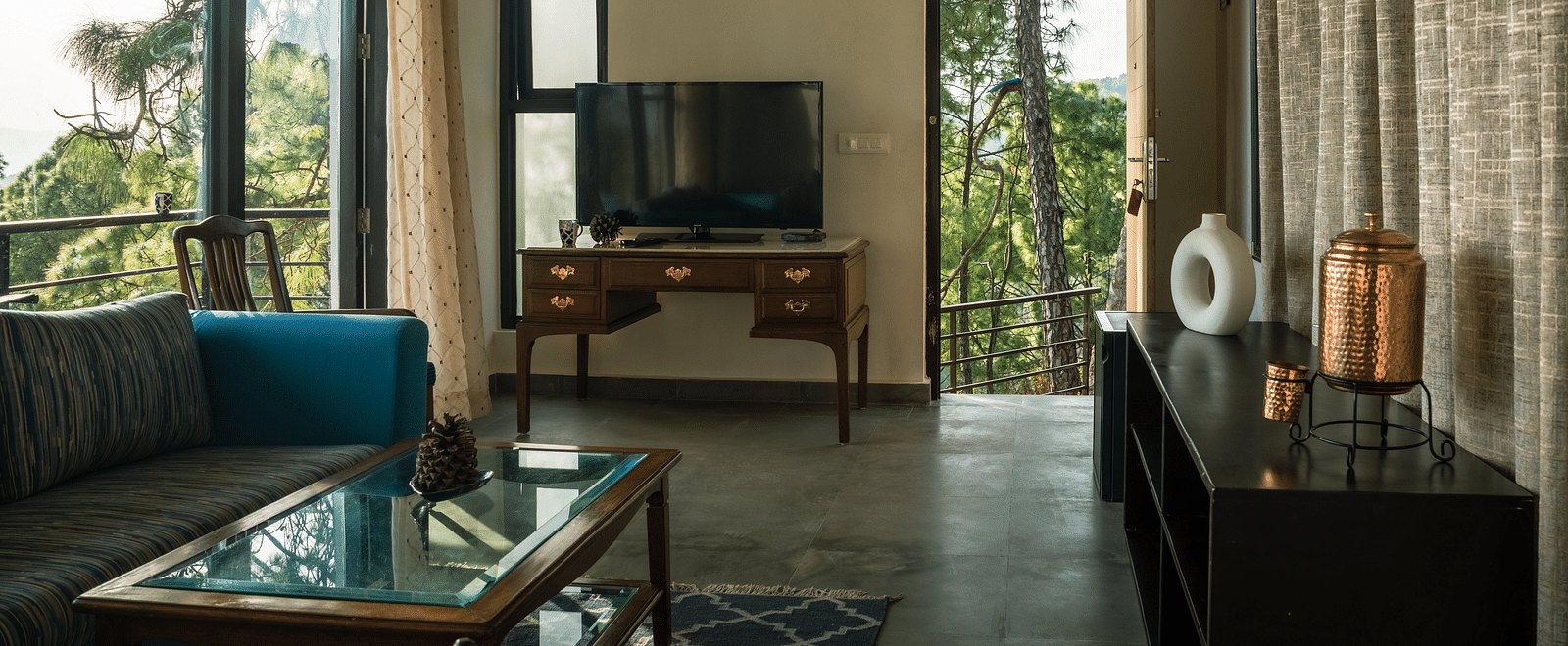 A living room featuring sofas, a table, and a television at BluSalzz Escapade Resort, Lansdowne