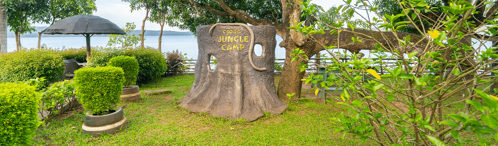 Image of an outdoor area with a faux tree stump in the centre at Coorg Jungle Camp.