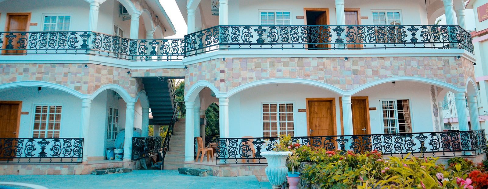facade image of our hotel in birbhum in bright daylight highlighting the cyan coloured walls of the building 