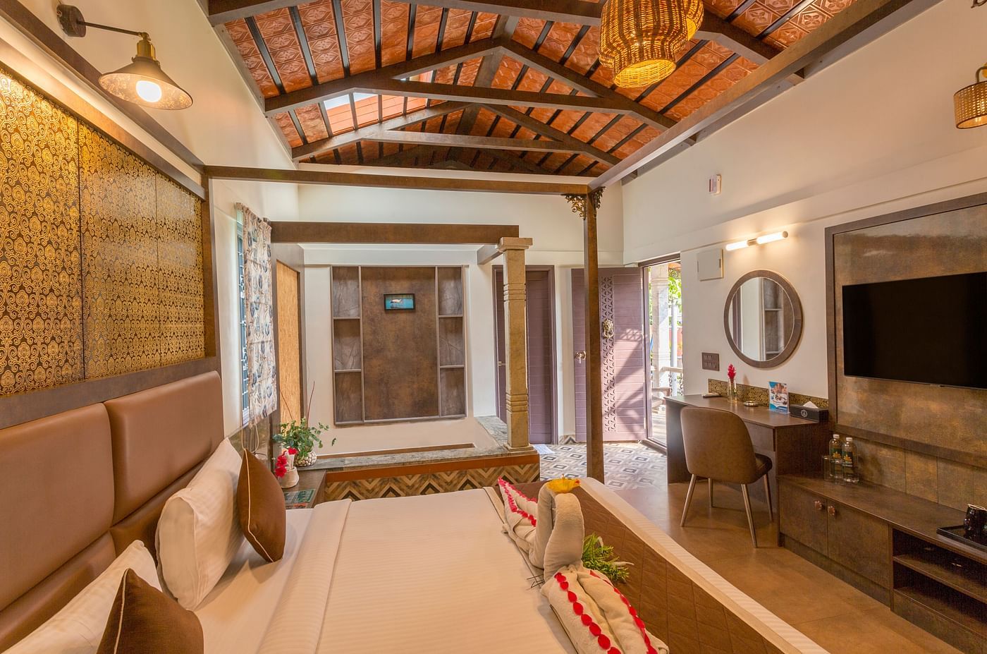 Elegant room with four poster bed and sitting area at Nirantara Resort