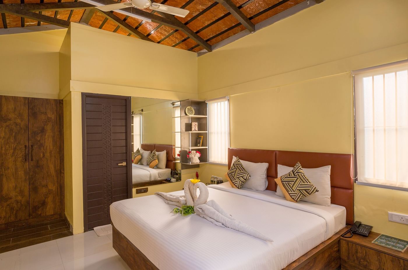 Cosy bedroom with elegant decor and wooden furnishings – Nirantara Resort & Spa