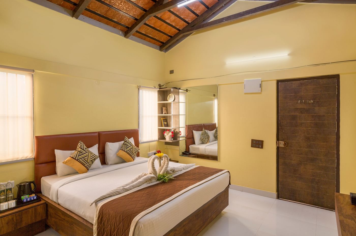 Spacious bedroom with double bed and wooden ceiling – Nirantara Resort & Spa