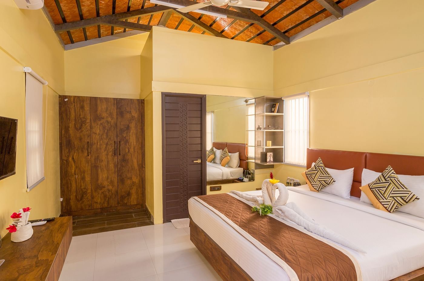 Well-lit bedroom with twin beds and rustic ceiling – Nirantara Resort & Spa