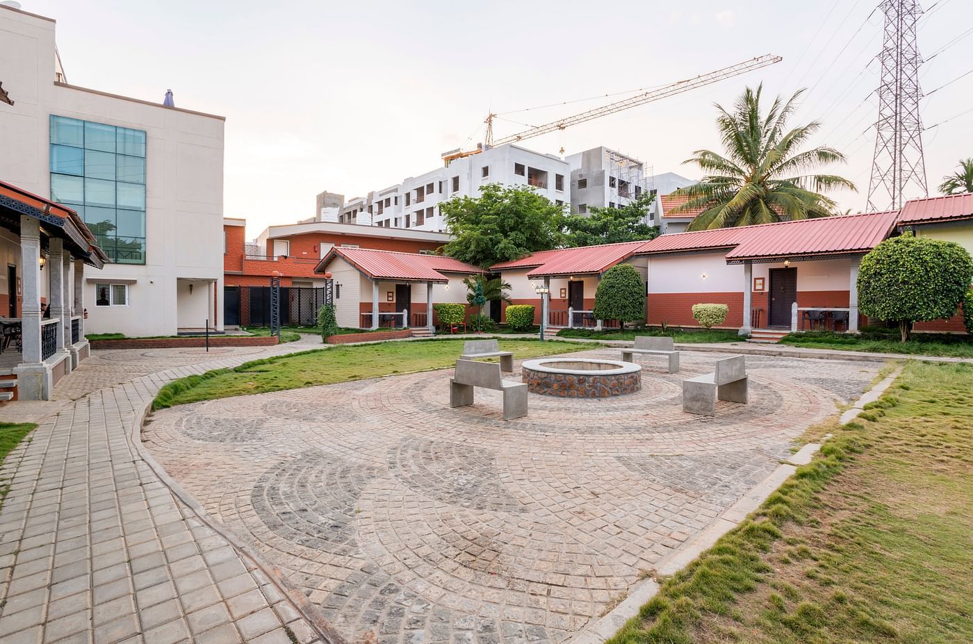 Courtyard area with stone seating and cottage surroundings at Nirantara Resort