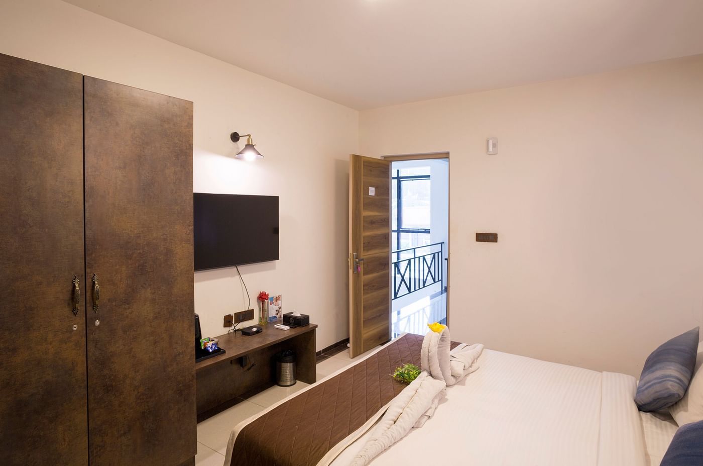 Room with double bed, wardrobe, and work desk – Nirantara Resort & Spa