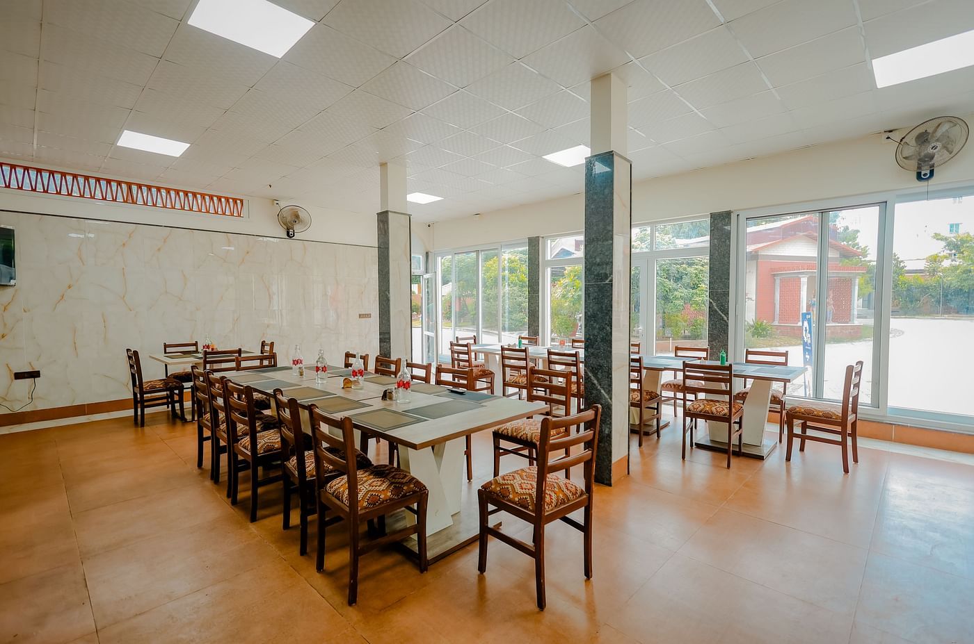 A dining area or event space with long tables and chairs at Nirantara Resort & Spa.