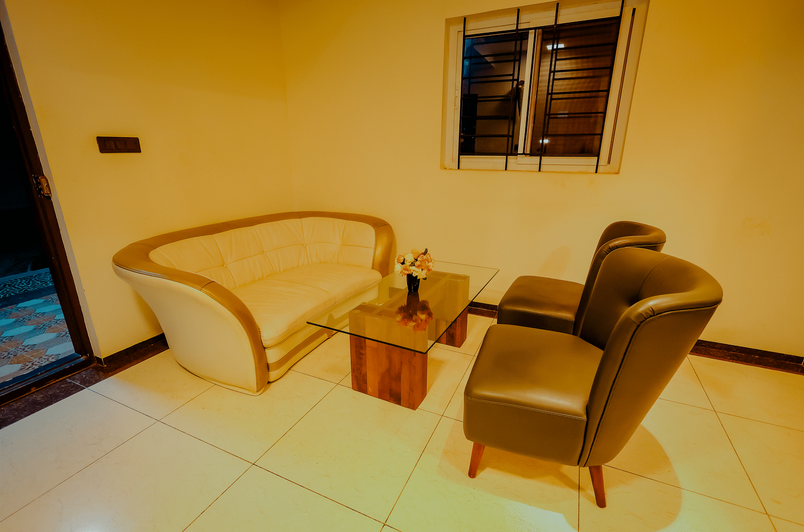 A seating area with a sofa and chair in a room at Nirantara Resort & Spa.