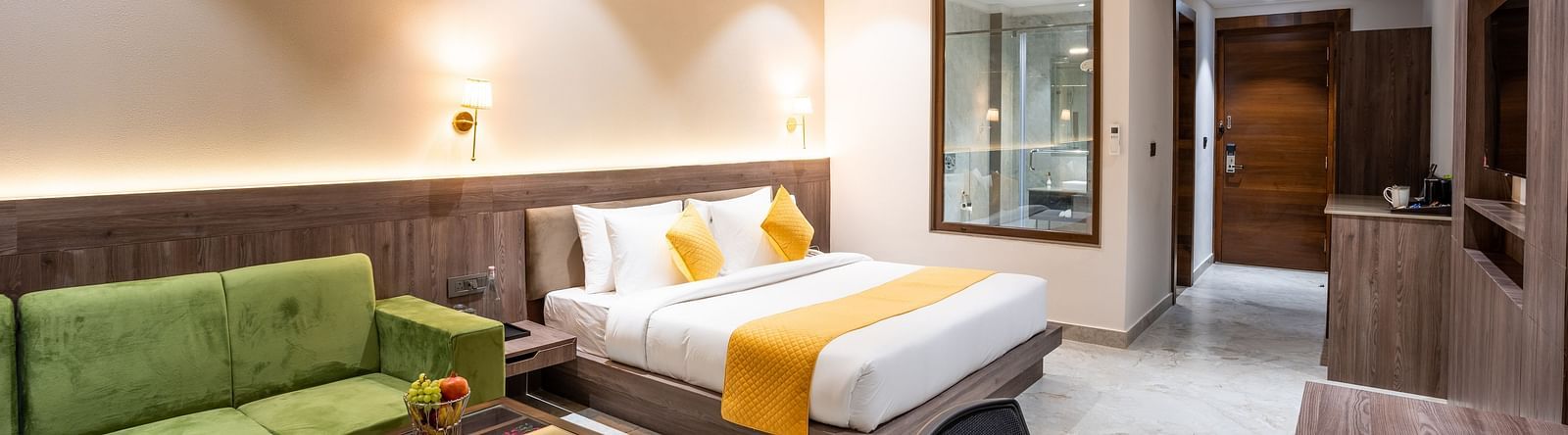 A premium room with a large bed, green sofas, a coffee table and a work desk - Shervani Pebbles & Pines, Corbett