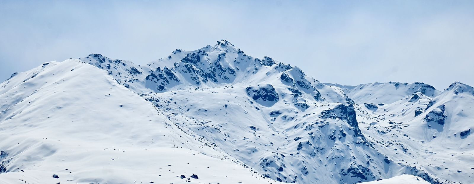 A picture featuring snow capped mountains captured in the day time.