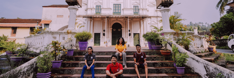Guests standing in front of a white colonial-style church near Heritage Village Resorts & Spa, Goa.