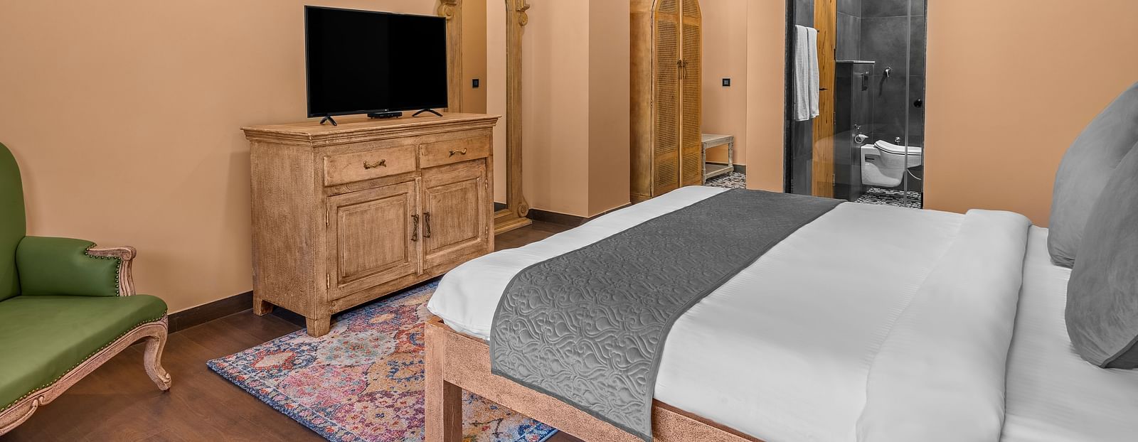 a bedroom with a large bed facing a television - Atman, Dharamshala