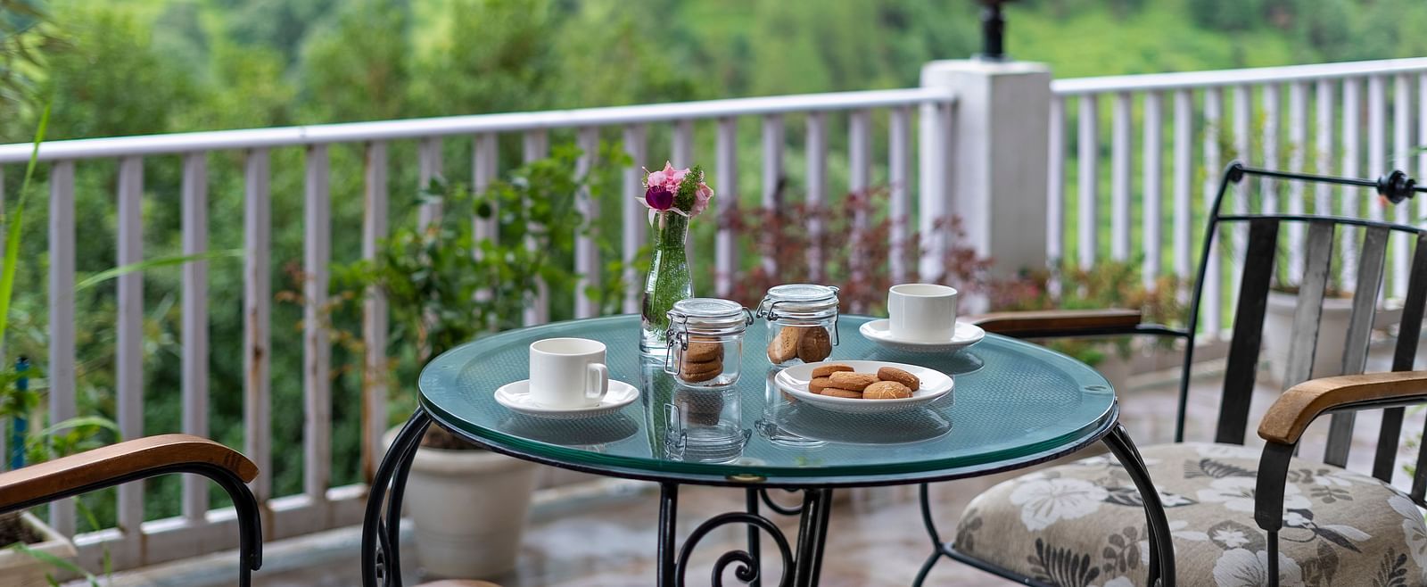 Scenic outdoor tea setup with pastries overlooking lush green hills at BluSalzz Collection - Suvaasa Resort, Ramgarh.