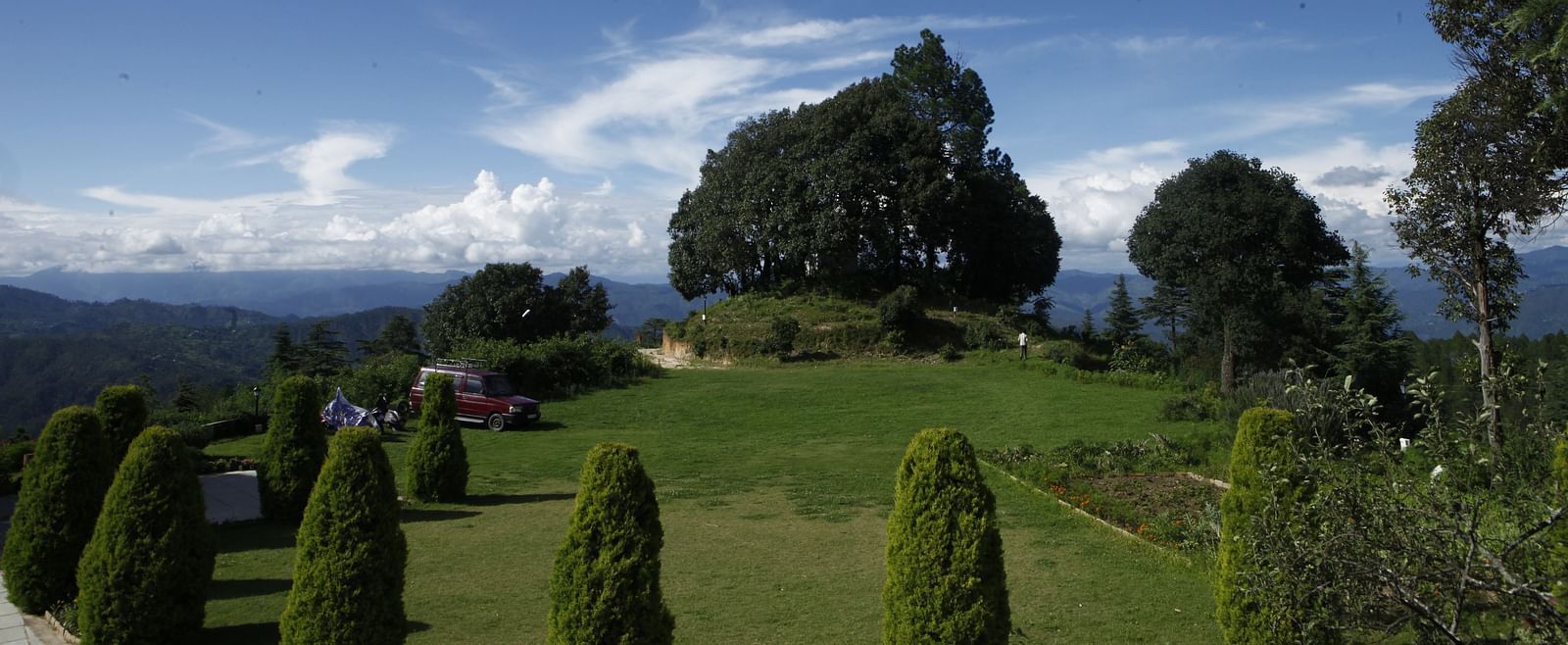 A vibrant wedding lawn in Almora with a scenic backdrop of hills and trees - BluSalzz Escapade - Anant Rasa Resort
