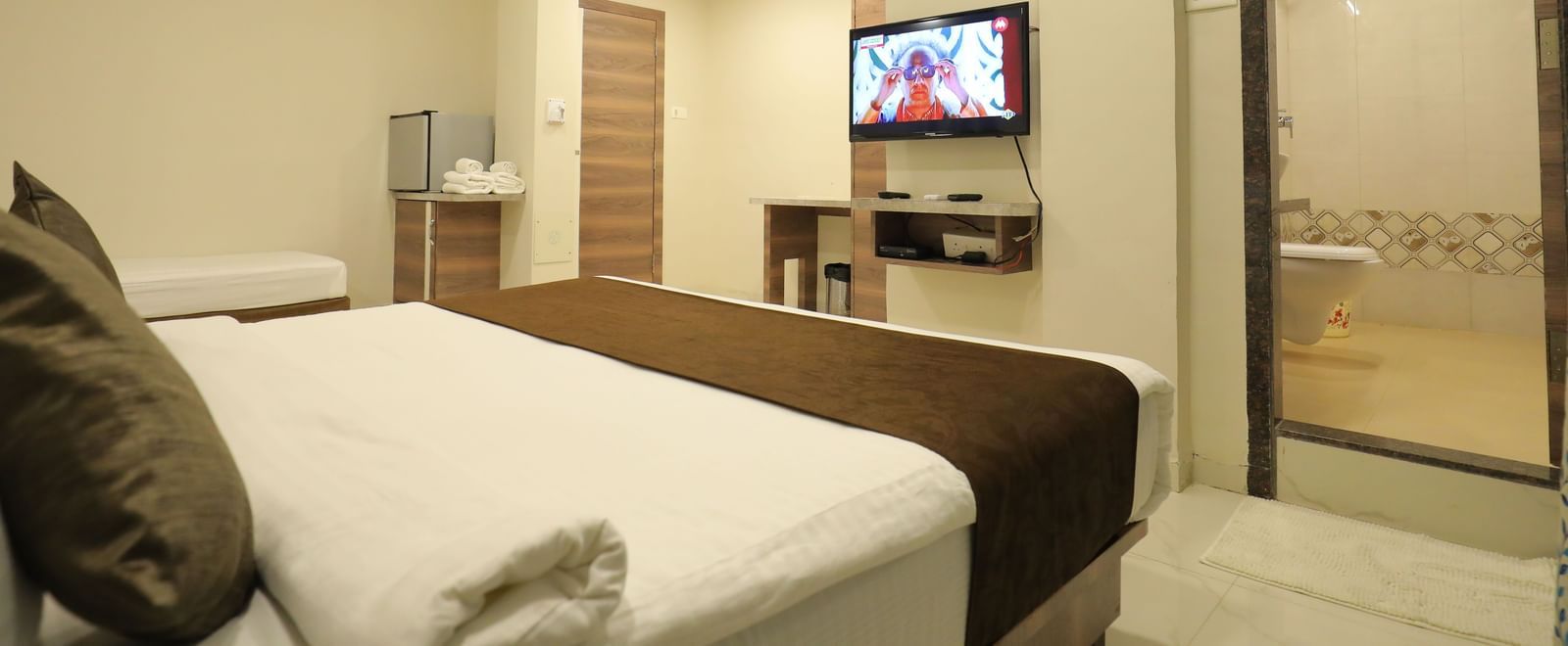 The king size bed and single bed in Highland Resort's suite facing the wall-mounted TV.