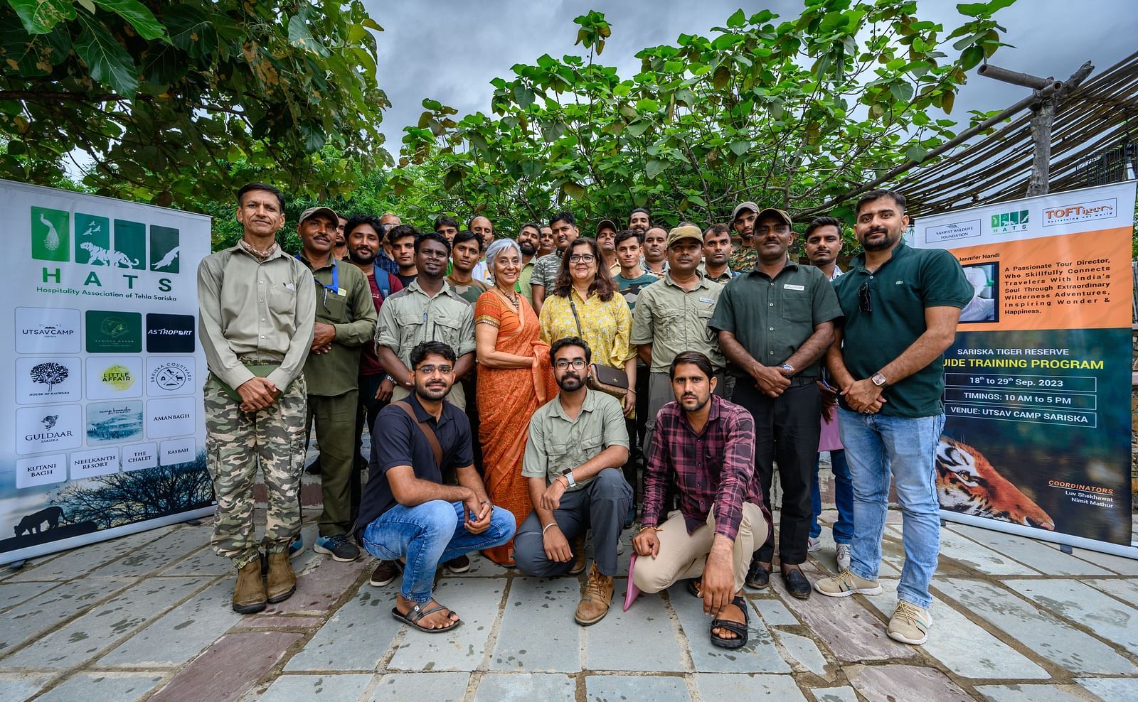 A group of people posing with banners behind them - Utsav Camp