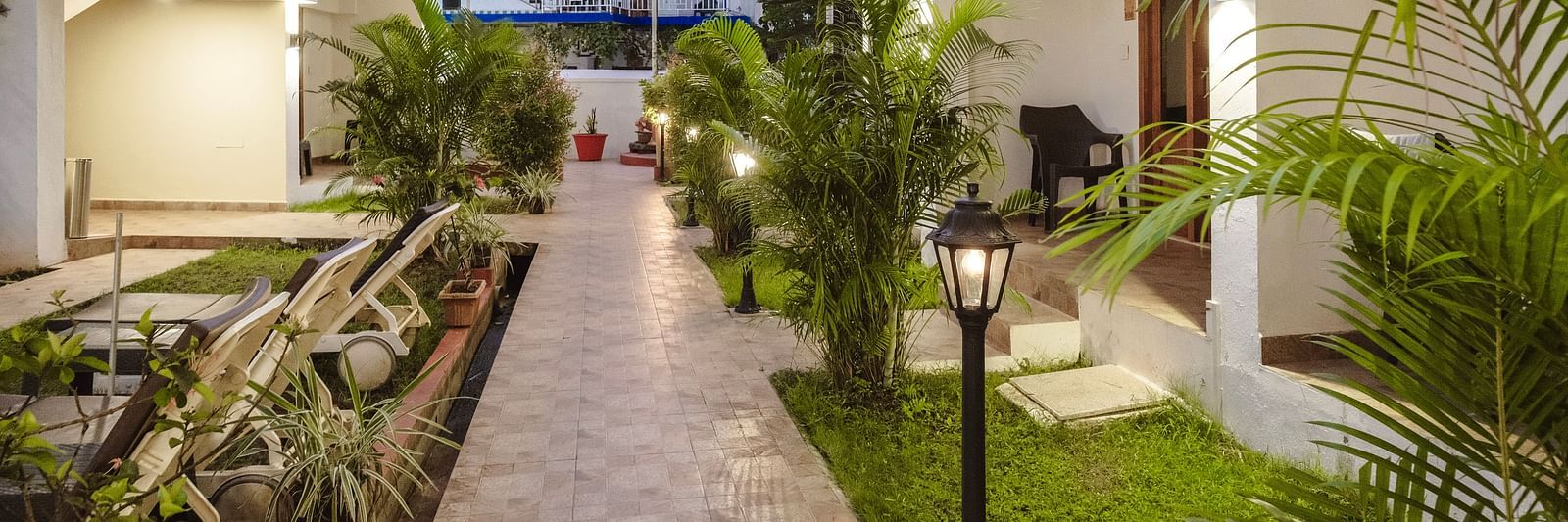 Paved garden pathway lined with plants and traditional lanterns at The Verda de Miranda Resort.