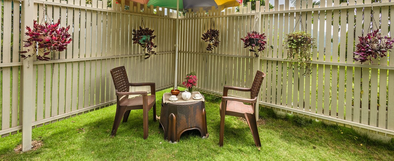 two chairs and a small table in between with a canopy above in a garden area - neer ganga resorts