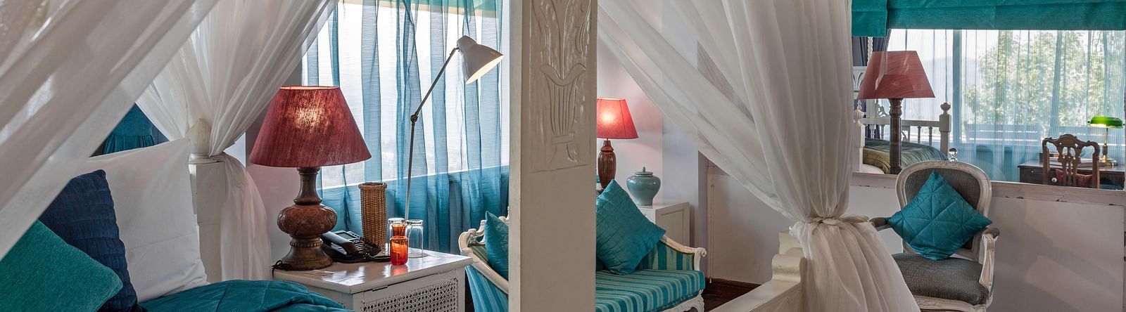 Close up view of a bed with side canopy and lamp on the side of the bed at Bed with side canopy and a lamp on the side of the bed at 3 bhk cottage at Te Aroha by Shervani Mukteshwar