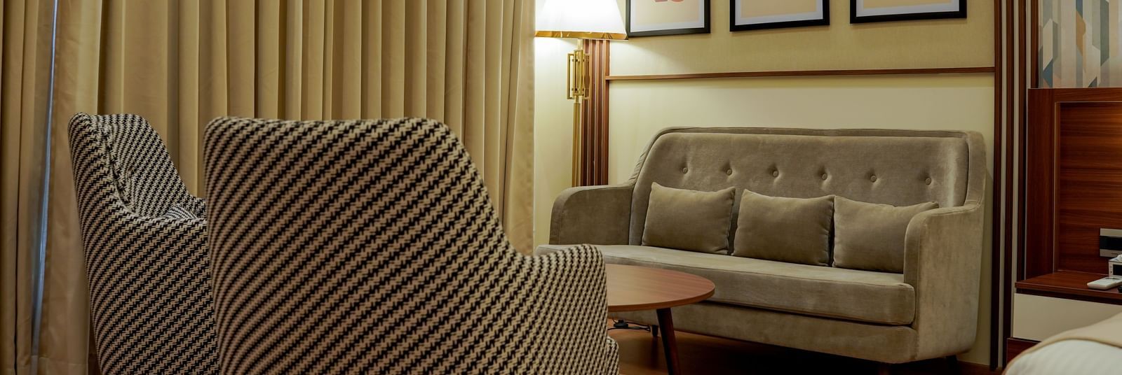 A close-up shot of the separate seating area with a tall lamp in the corner in the premium room at M2 Square by Monday Premium.