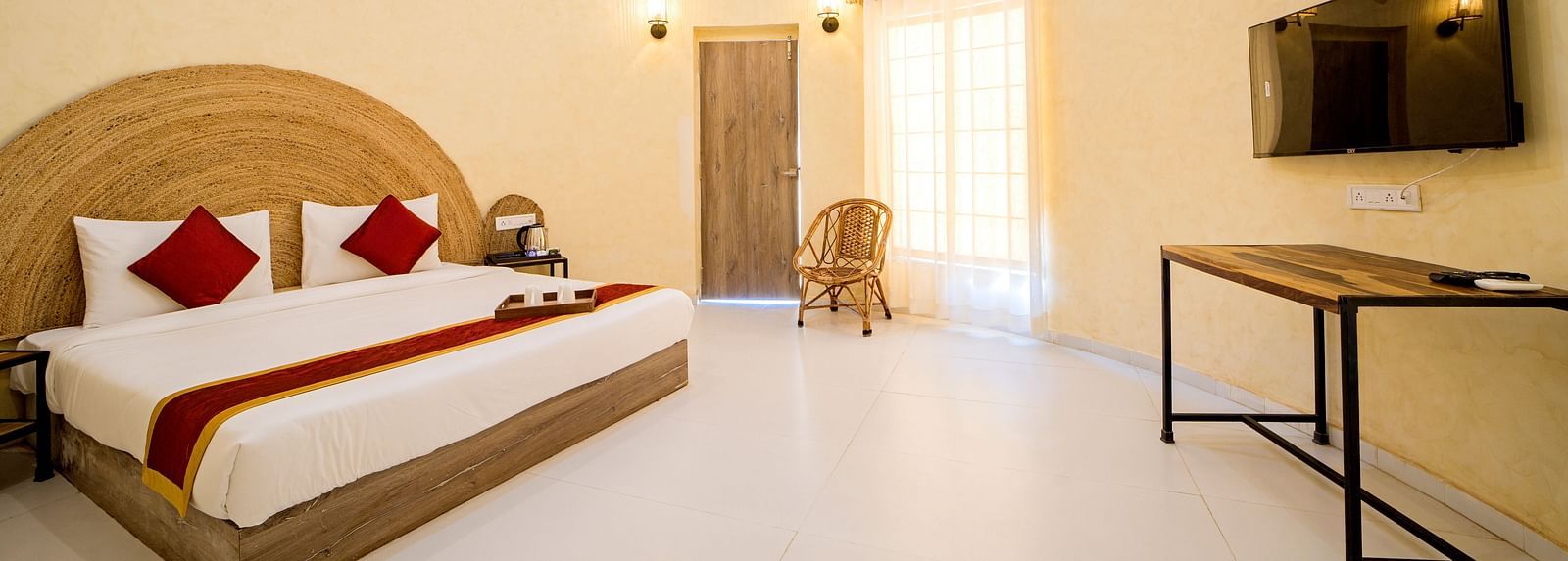 Side view of a room with a bed, a television and a table at Valley by Grassfield.