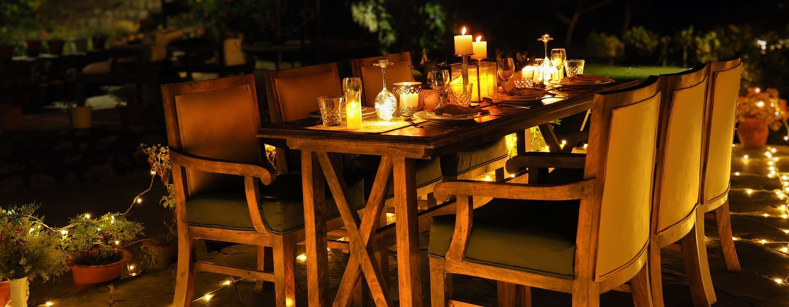 A lavish open-air dining setup at night at The Sylvan Retreat, Dehradun.
