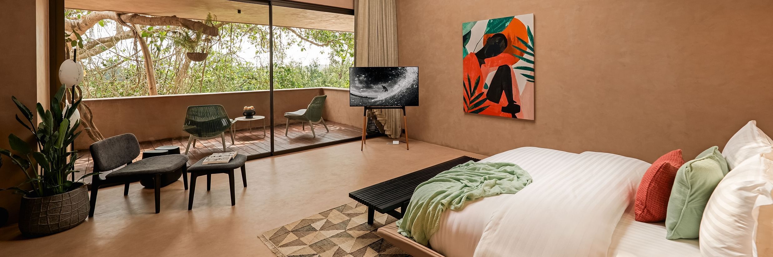 Spacious villa bedroom with earthy tones, large windows, and modern decor overlooking lush greenery at Villa Moira