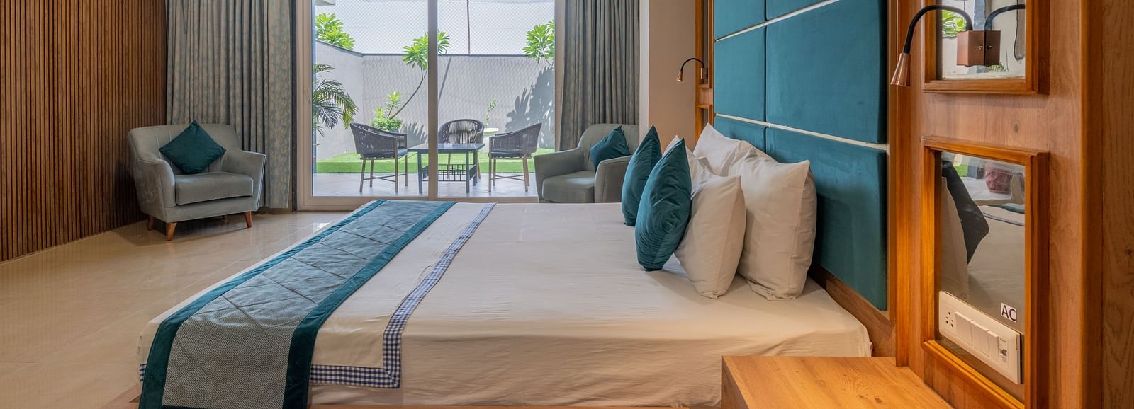 A well-appointed guest room with a large bed and a view of the outside area at Hotel Highway King Shahpura.