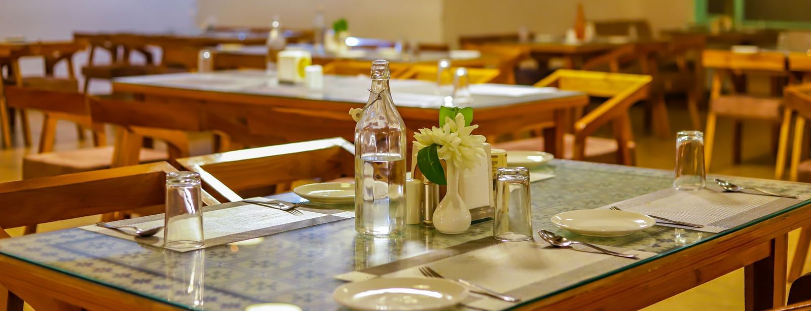 An empty dining space at Vedikant Resorts The Mallard Corbett shows set tables and chairs awaiting guests.