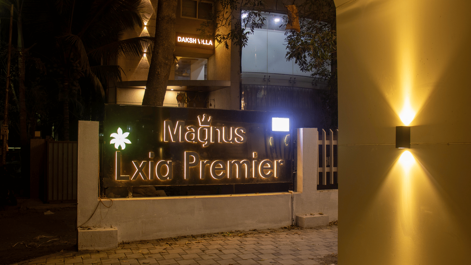 The hotel entrance signage and gate area at night at Magnus Lxia Premier, Kalyani Nagar.