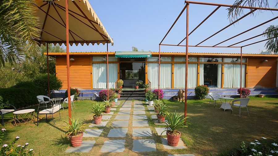 Elegant pathway leading into the hotel, featuring a roofed shed and small potted plants lining the side at Aanandam Resort & Spa