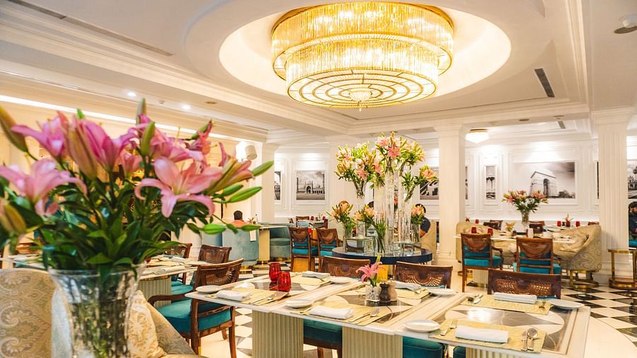 A beautifully designed restaurant featuring a grand chandelier, floral arrangements, and stylish seating