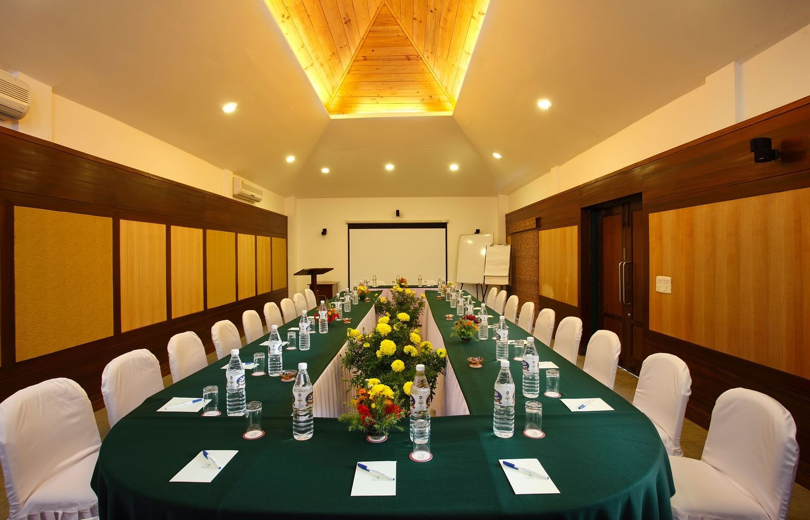 A conference room setup with a long table and chairs arranged symmetrically.