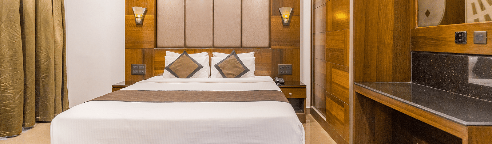A room with a bed and a window on the side at Hotel Altitude, Madikeri.