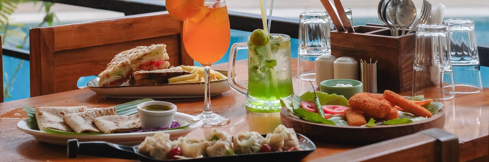 A tropical-style breakfast spread with fresh juice, salads, and continental dishes on a patio table – The Verda de Miranda Resort.