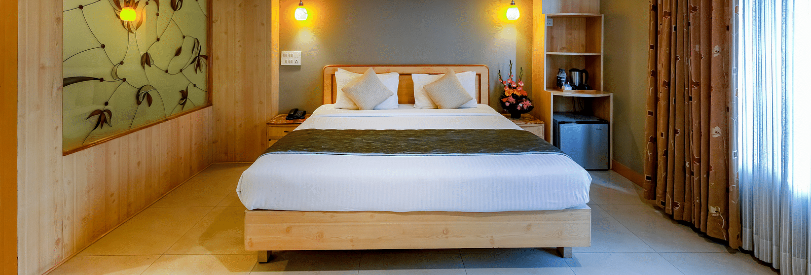 An elegant Suite with a stylish headboard and large bed - Cross Roads Inn, Bengaluru